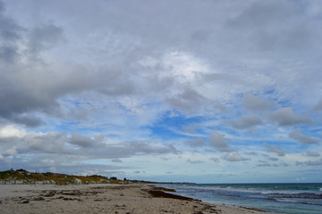Landscape of a beach at sunset with clouds and ocean in the horizon