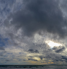 Landscape of a beach at sunset with clouds and ocean in the horizon