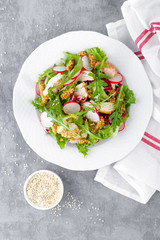 Light spring vegetable salad with radish, lettuce, arugula and chicken meat