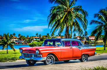 Amerikanischer roter Ford Oldtimer parkt am Strand unter Palmen in Varadero Cuba - Serie Cuba...