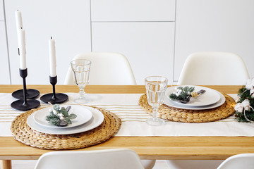 Christmas dinner by candlelight, table setting in in modern kitchen.