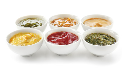 Different tasty sauces in bowls on white background