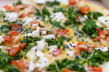 Pizza with feta and spinach closeup.