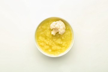 Bowl with healthy vegetable puree for baby on white background, top view
