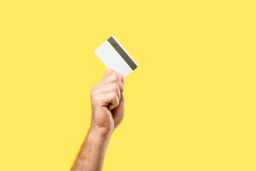 Fototapeta na wymiar cropped shot of person holding credit card isolated on yellow