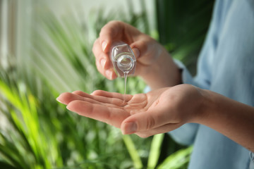 Woman using antibacterial hand gel, closeup