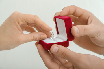 Hands of young man proposing to his beloved on white background, closeup