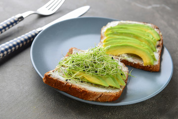 Tasty toasts with avocado on plate