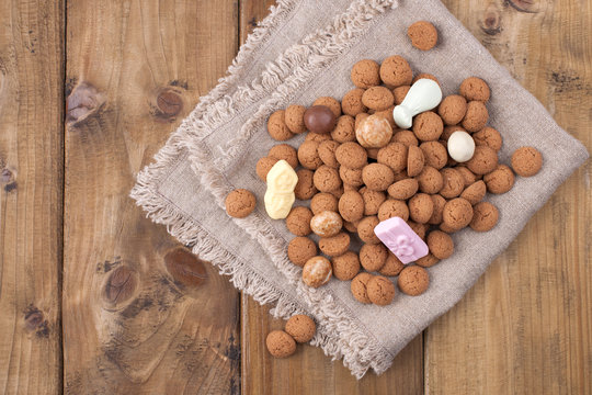 Dutch holiday Sinterklaas background , gifts, pepernoten, traditional sweets strooigoed . Flat lay and copy space. wooden background.