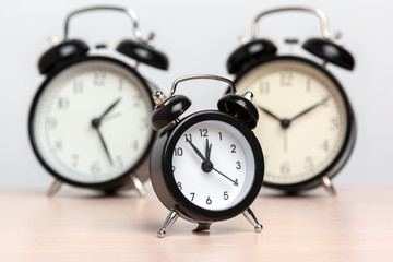 Different alarm clocks on table. Time change concept
