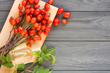 Medicinal plants and herbs composition: yellow and red wild dog rose, bunch branch types Rosa canina hips, essential oil. 