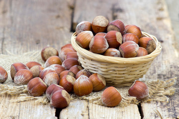 hazelnuts in a basket on old wooden background
