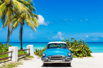 Amerikanischer blauer Oldtimer parkt vor dem Strand in Varadero Cuba - Serie Cuba Reportage - obrazy, fototapety, plakaty