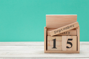 wooden cube shape calendar for september 15 on wooden tabletop