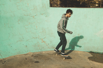 Guy practicing skateboarding and doing tricks in a skatepark