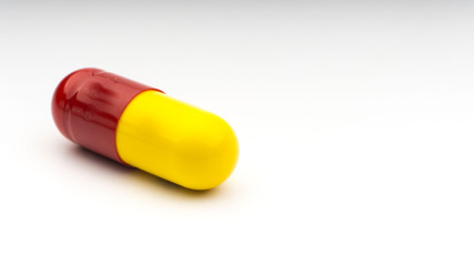 Medicine pills or capsules closeup on a white background with selective focus and crop fragment