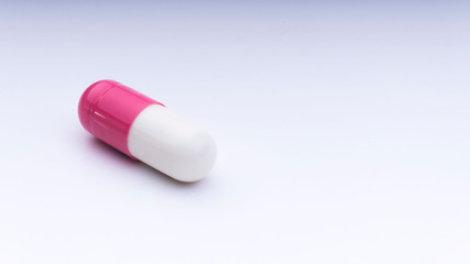 Medicine pills or capsules closeup on a white background with selective focus and crop fragment