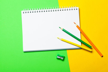 Blank notepad and pencil color on a table blackground