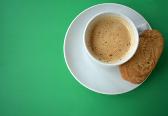 Cup of coffee on a green background.
