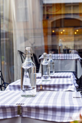Bottles of clear water are on a tables in restourant.