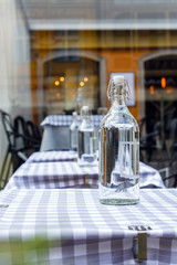Bottles of clear water are on a tables in restourant.