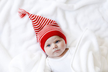 Cute adorable baby child with Christmas winter cap on white background. Happy baby girl or boy smiling and looking at the camera. Close-up for xmas holiday and family concept