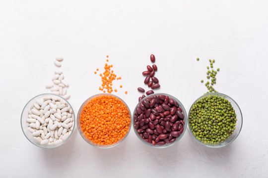 Lentils in glasses on the table. This legume contains a lot of vegetable protein. Top view on white background