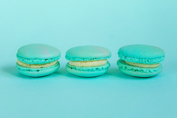 Sweet almond colorful unicorn blue macaron or macaroon dessert cake isolated on trendy blue pastel background. French sweet cookie. Minimal food bakery concept. Flat lay top view copy space