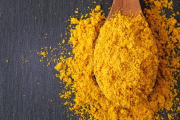 Turmeric powder (Curcuma), also known as Indian saffron. Top view with copy space