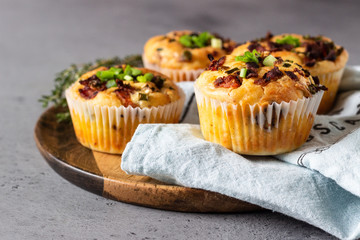 Savory muffins with bacon, quail egg, green onion cheese on a grey stone backdrop. Protein breakfast. Rustic style.