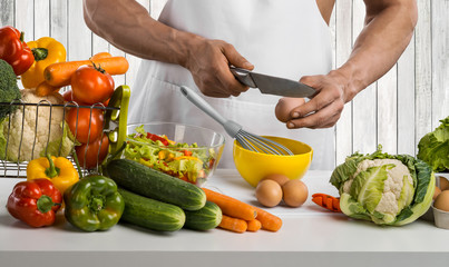 man hand cook make omelette, beating whisk eggs, on kitchen