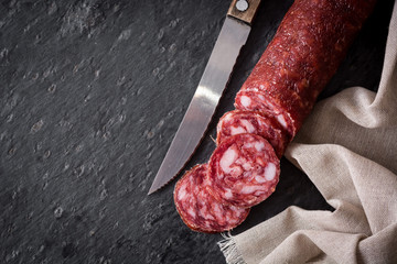 Cold meat chorizo on black slate background. Top view. Copyspace