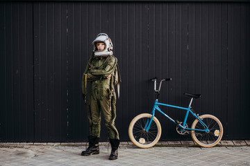 Fototapeta Portrait of a boy on a bicycle in street astronaut dress obraz