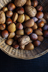 vertical close-up of nuts, hazelnuts and almonds in a basket