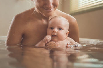 baby bathing with mother in the bathroom