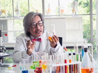 Asia scientific researcher holding a test tube of clear solution in a lab