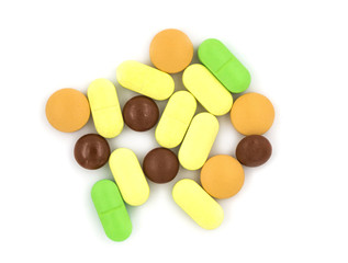 Multicolored tablets and pills on a white background