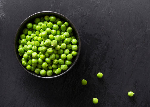 Raw green peas in a bowl.