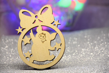 Wooden Chinese new year toy with funny pig and stars on beautiful background. Christmas shiny glittery backdrop with blurred bokeh light. New year 2019 greeting card with holiday decoration.