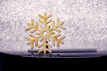 Wooden beautiful snowflake on white sparkle background. Christmas shiny glittery backdrop with...
