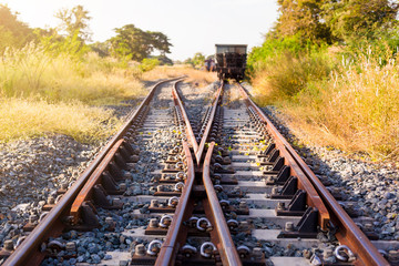Fototapeta premium Railroad switch with train in the morning sun. The conception of change or choices or decide.