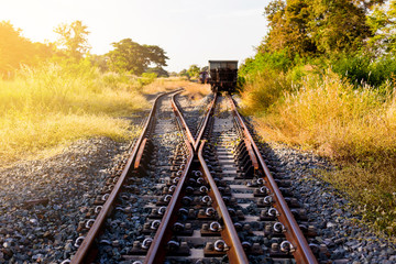 Obraz premium Railroad switch with train in the morning sun. The conception of change or choices or decide.