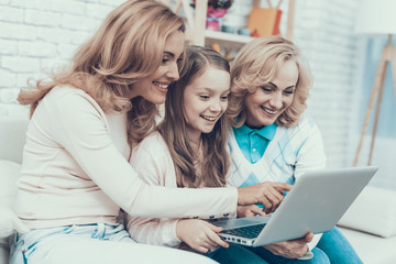 Happy Family Sitting on Sofa and Using Laptop.