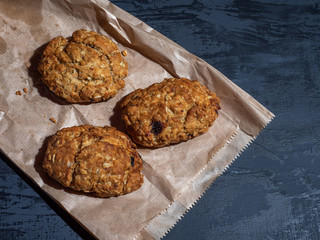 Oatmeal raisin cookies on a paper bag on a gray background