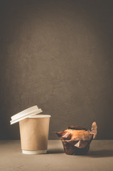 cake with a chocolate stuffing and cappuccino plastic cup/cake with a chocolate stuffing and cappuccino plastic cup on a dark background. Selective focus and copy space