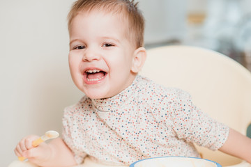 the kid in the kitchen eats milk porridge