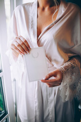 Wedding invitation card in the hands of the bride