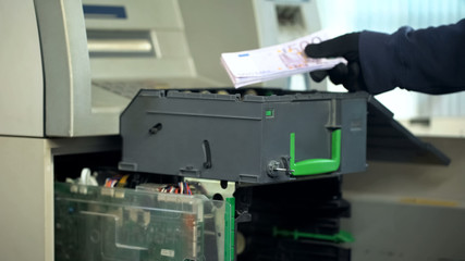Bank worker replenishing cases of ATM with euro currency, authorized access
