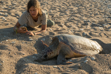 Girl near eggs laying turtle