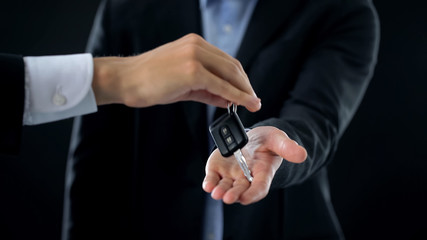 Man receiving car keys from agent, businessman buying auto, transport rent